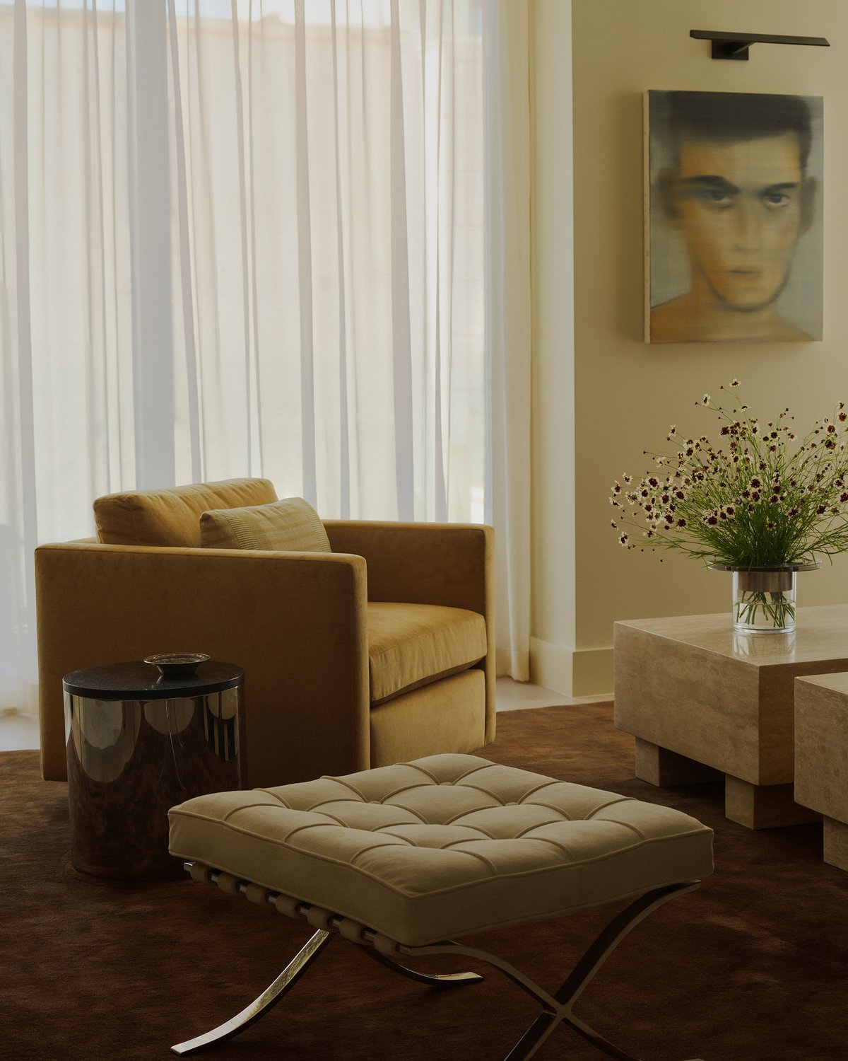 Grand Rug in Walnut adds rich warmth to a serene living room with flowing beige curtains and sculptural furniture.