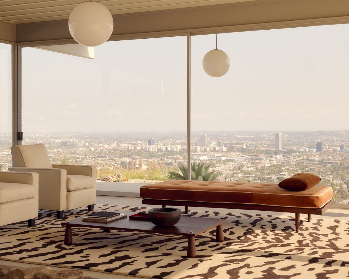Tigris Rug in Beige/Brown brings bold texture to a modern living room with panoramic city views, grounding neutral furniture in an organic, animal-inspired pattern.