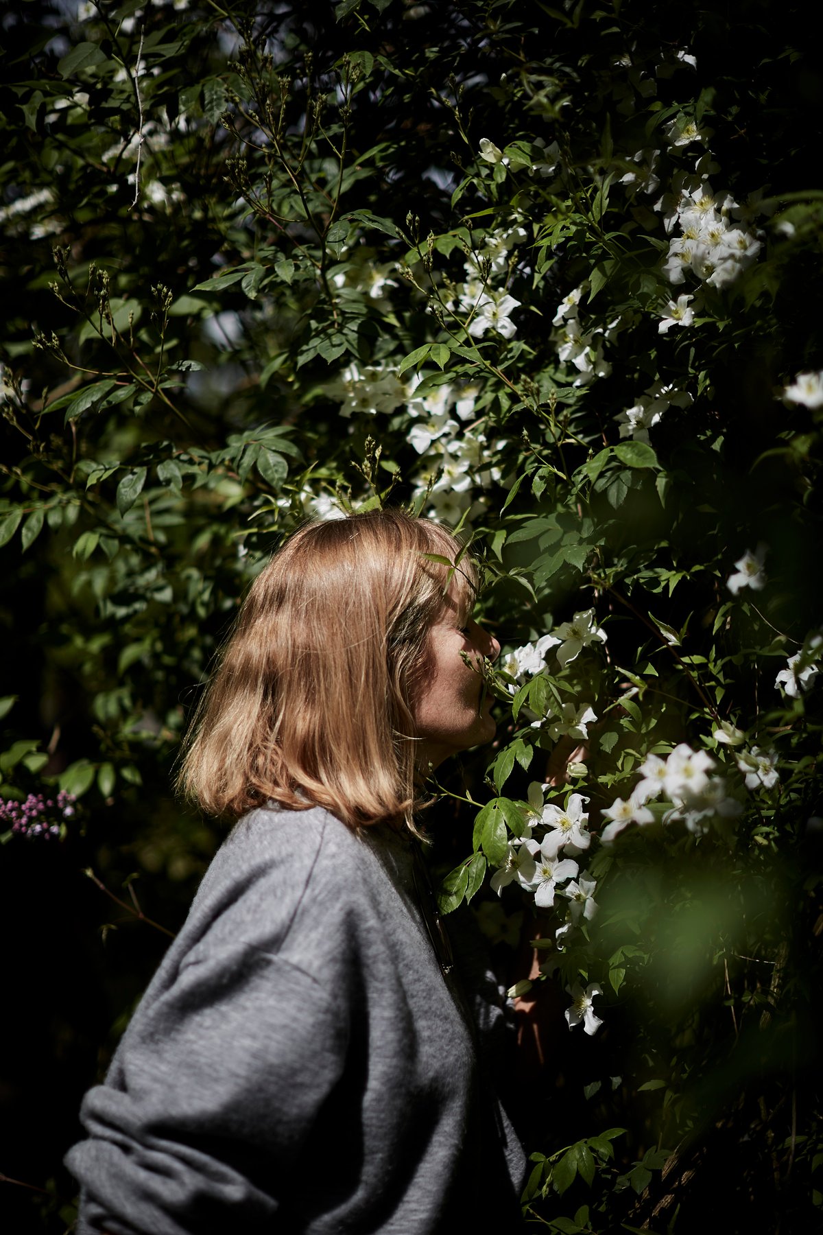 Skye Gyngell photographiée en train de sentir des fleurs.