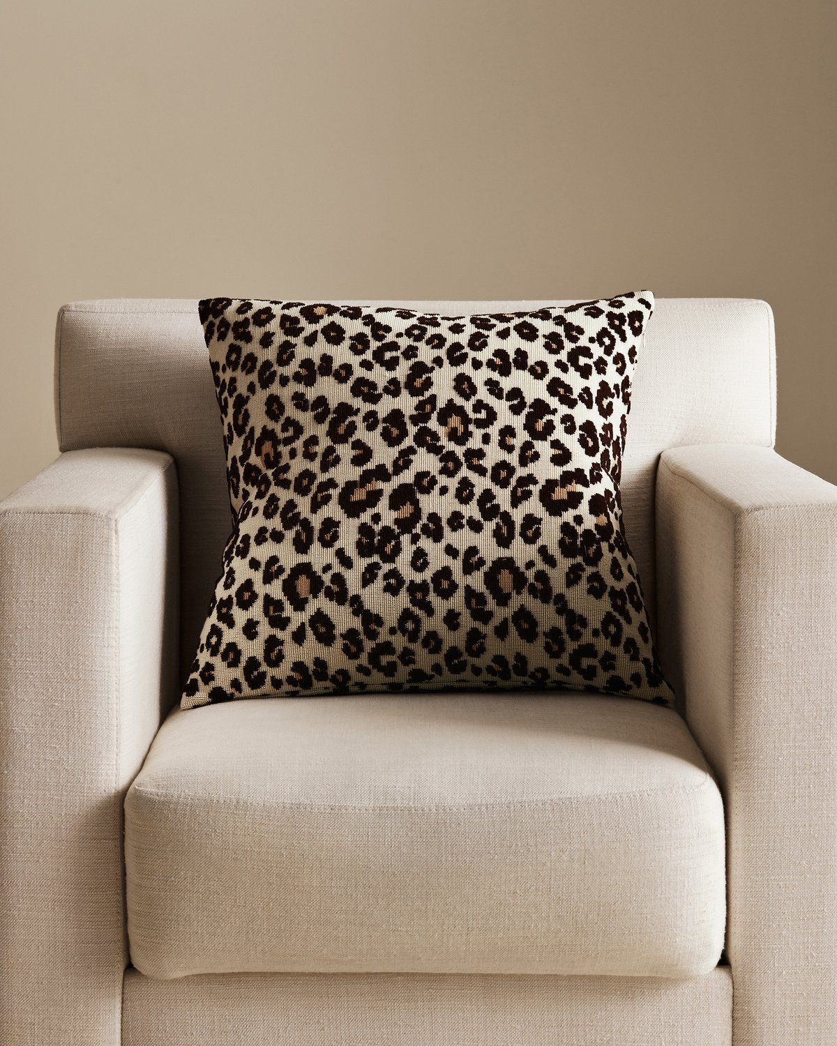 Leopard Pillow Cover in Beige, styled on a neutral armchair.