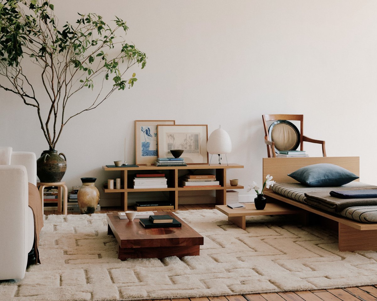 Boho 02 – Shearling rug, styled in a living room beneath low wooden tables and seating, showing its soft high-low pile and geometric pattern in warm off-white tones.