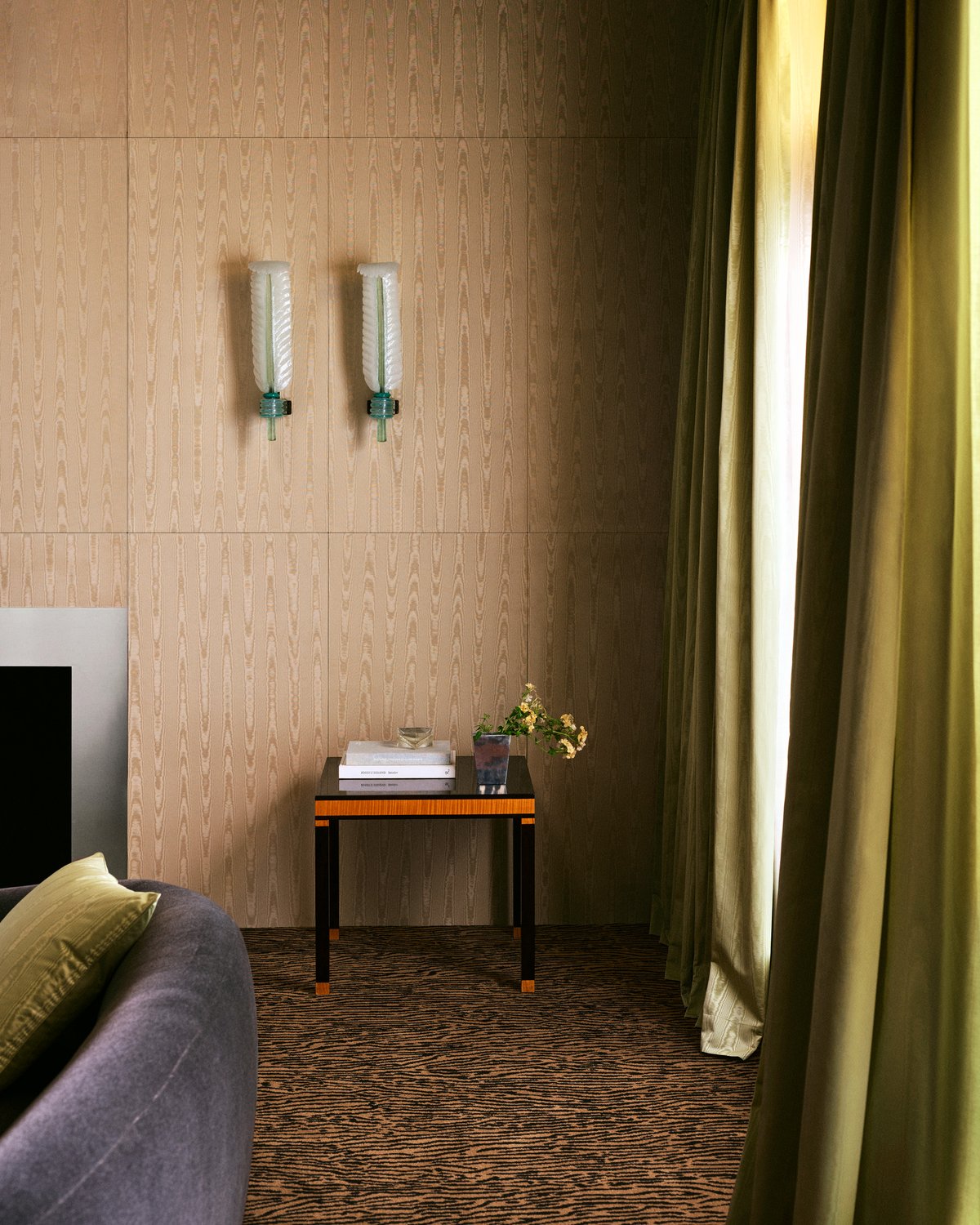The Moiré curtain in Pistachio, falling to the floor beside a small side table and moiré wall panels.