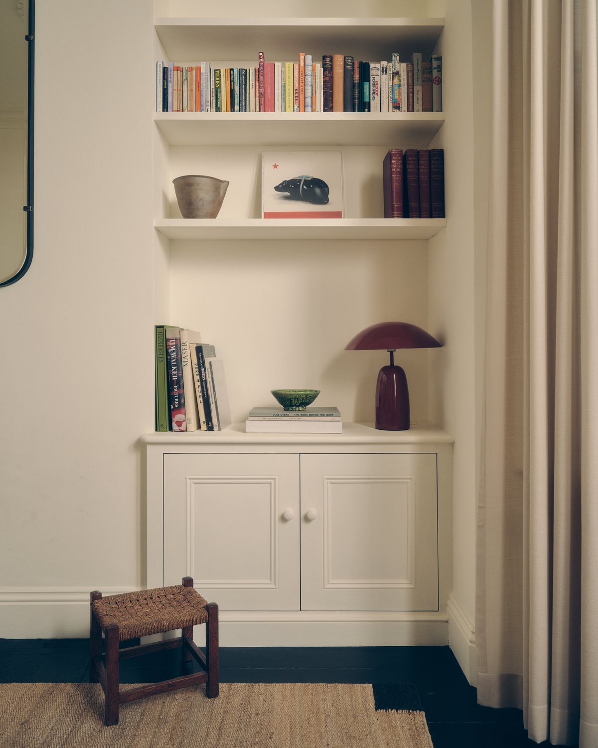 Tapis en jute Corner Black, photographié près d’une étagère.