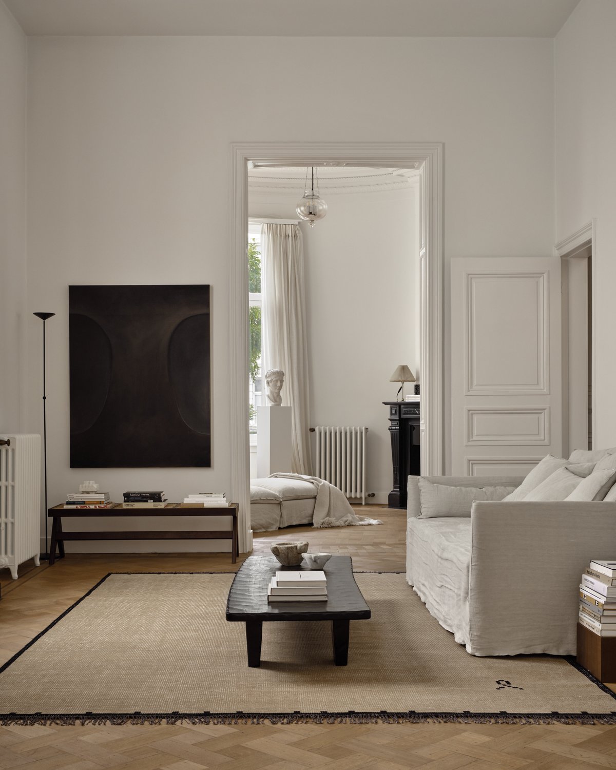 Elder 01 en Black, photographié avec une table basse rectangulaire noire et un canapé couleur sable dans un salon lumineux à Anvers, Belgique.