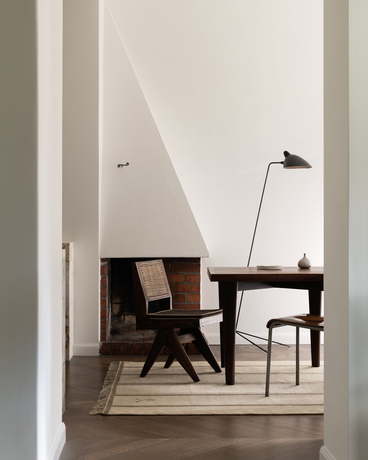 Elder 03 in color Olive styled in a minimalistic setting with wooden vintage furniture.