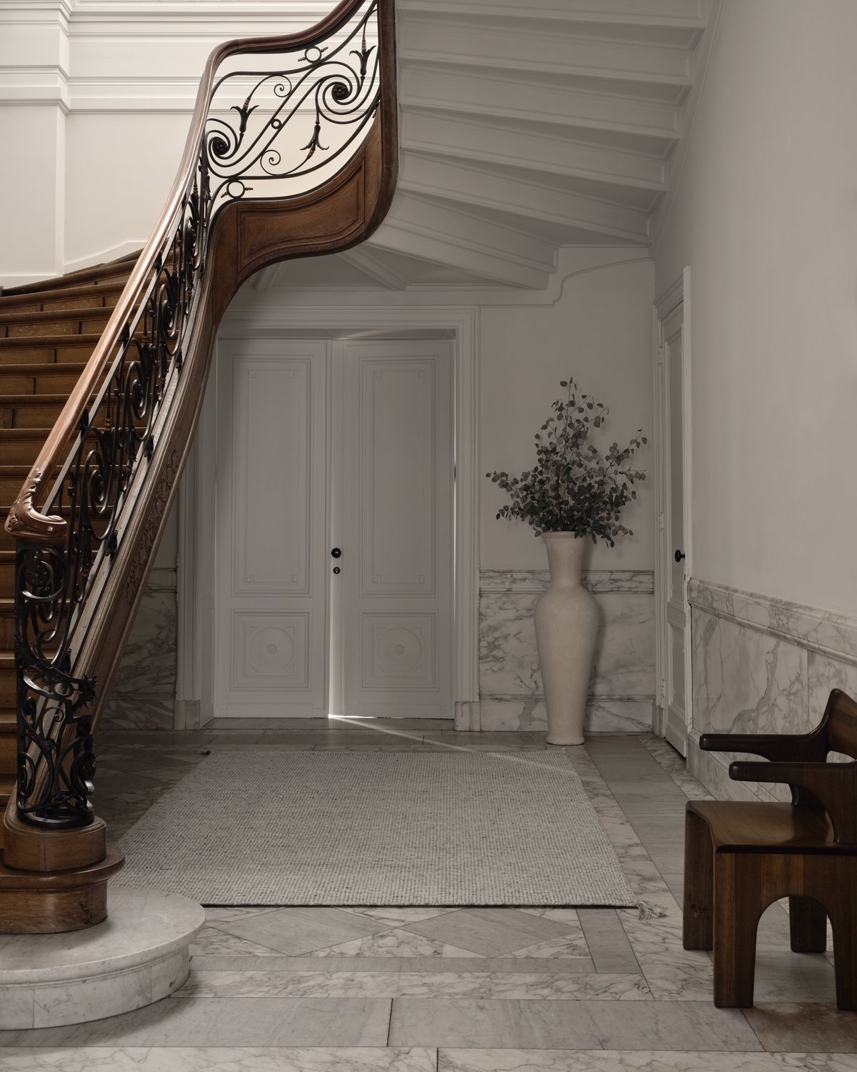 Bouclé i färgen Silver, stylad intill en vacker, storslagen trätrappa.