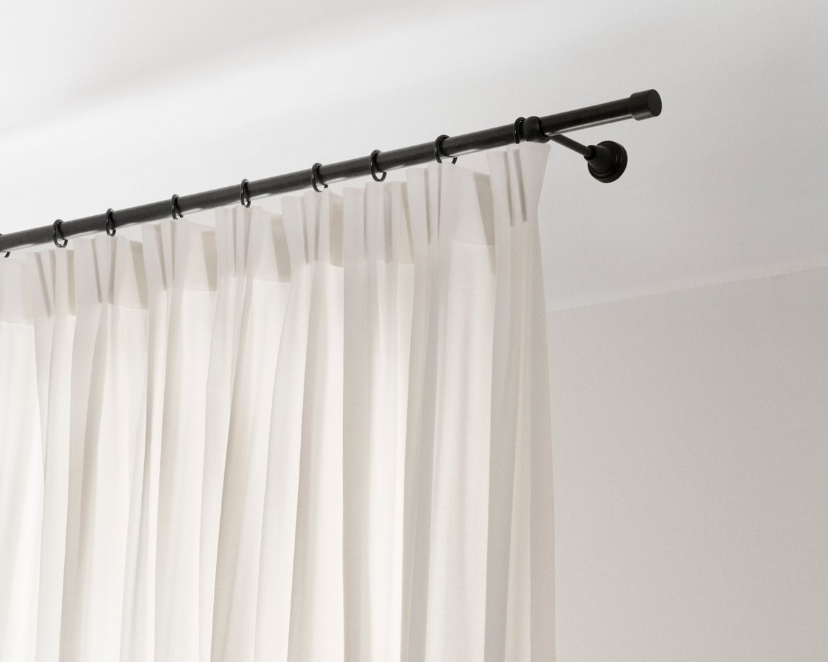 An image showing the installed The Grand wool curtains with the 4-finger hooks on a rod.