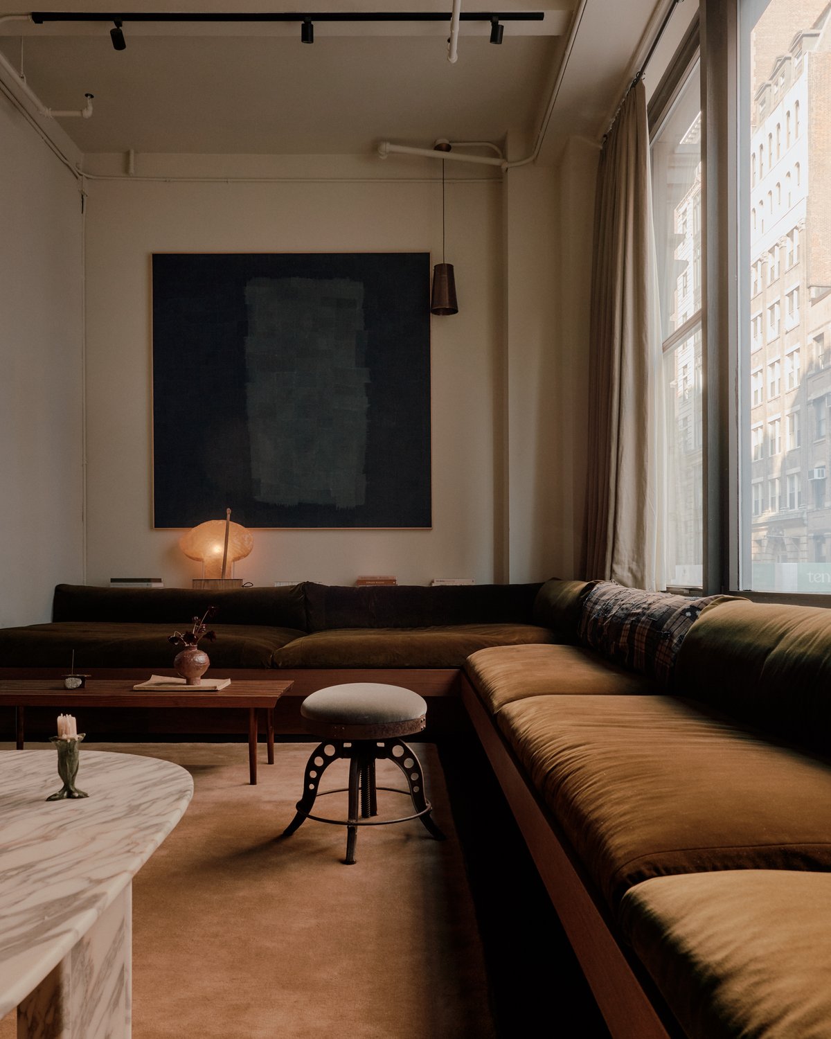 Moody living room with long sofa and the Grand – Chestnut rug.