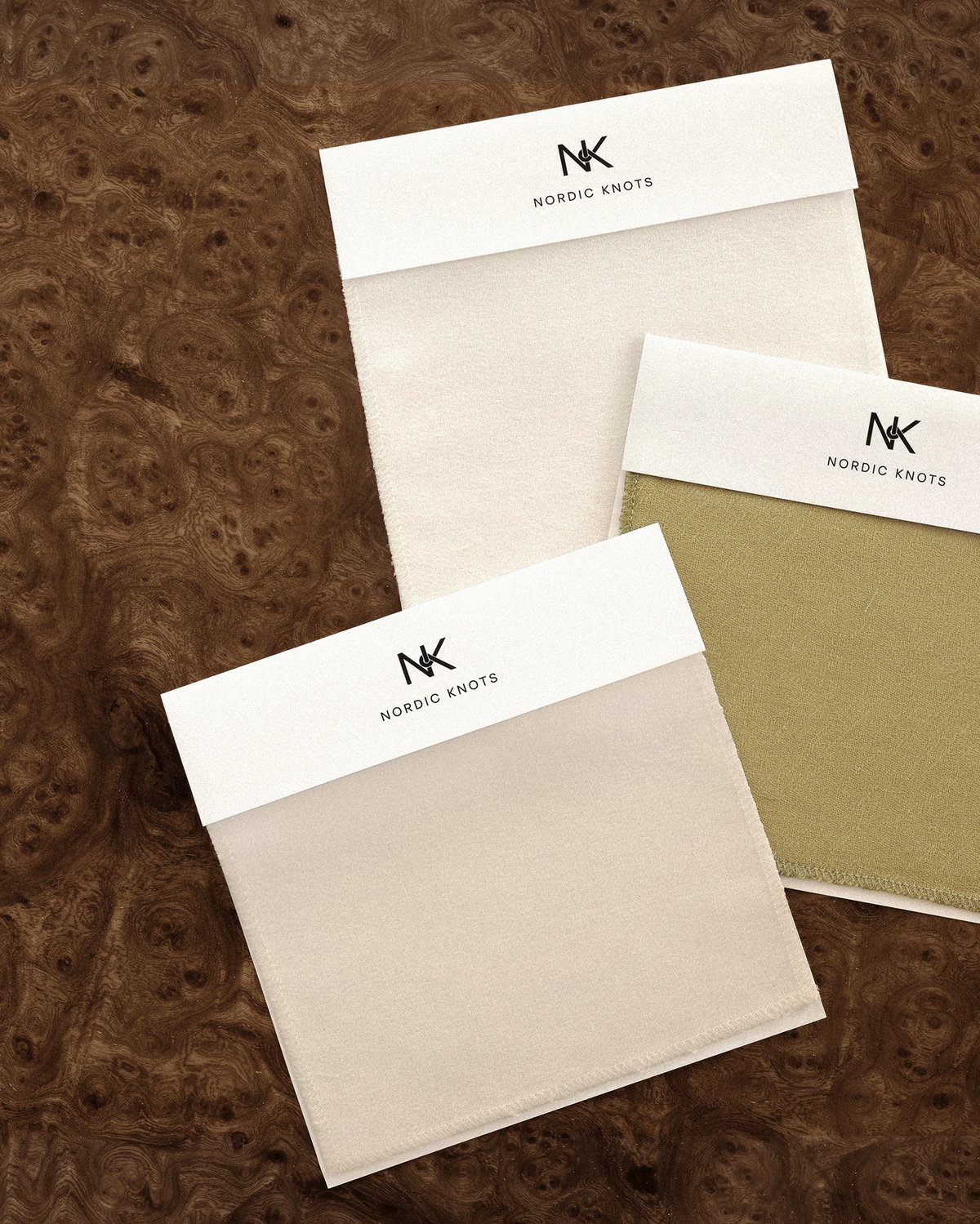 Three shades of curtain samples on a wooden background.