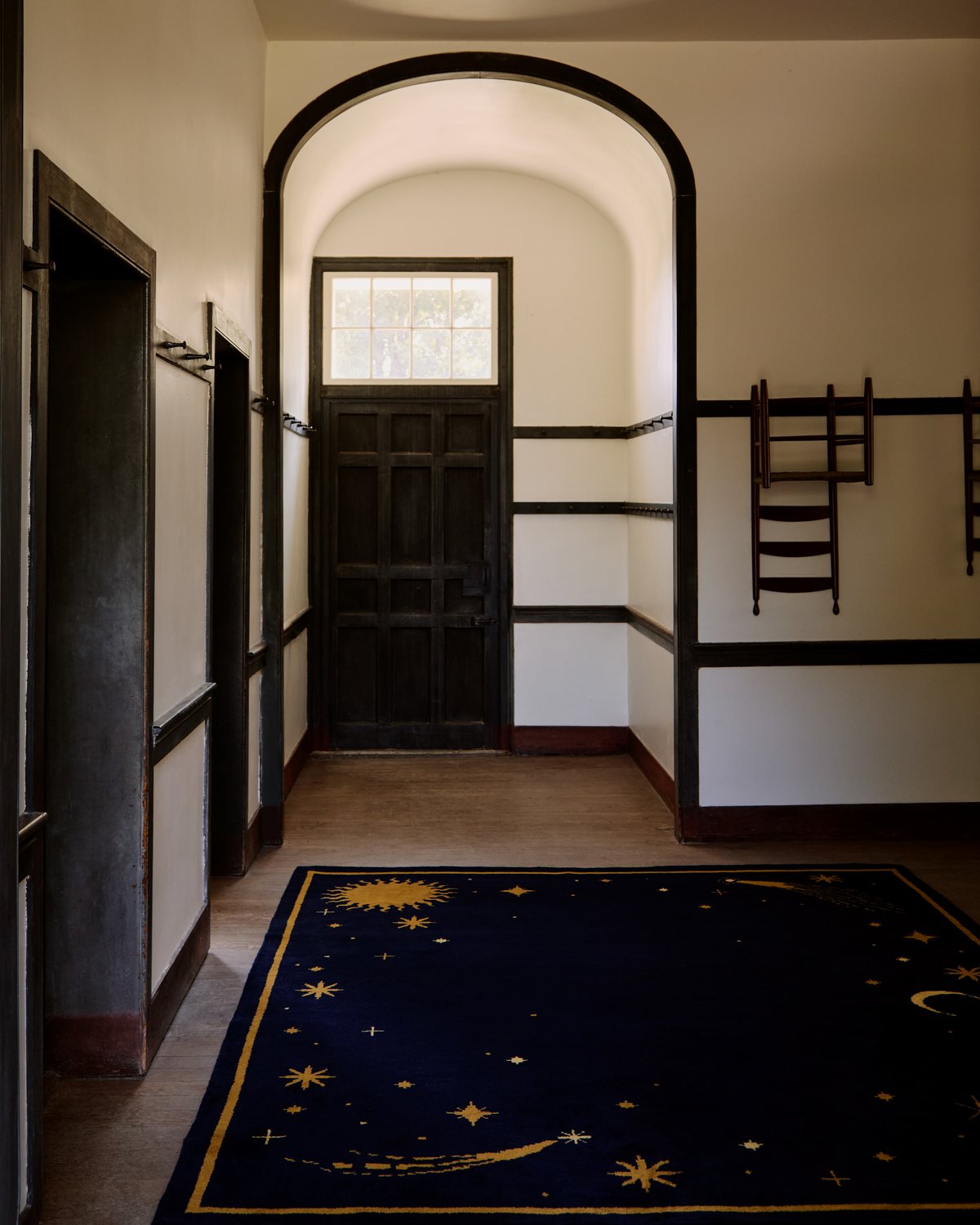 Plush wool rug Celestial in collaboration with ASH pictured in a spacious entrance hall with wooden beam detailing.