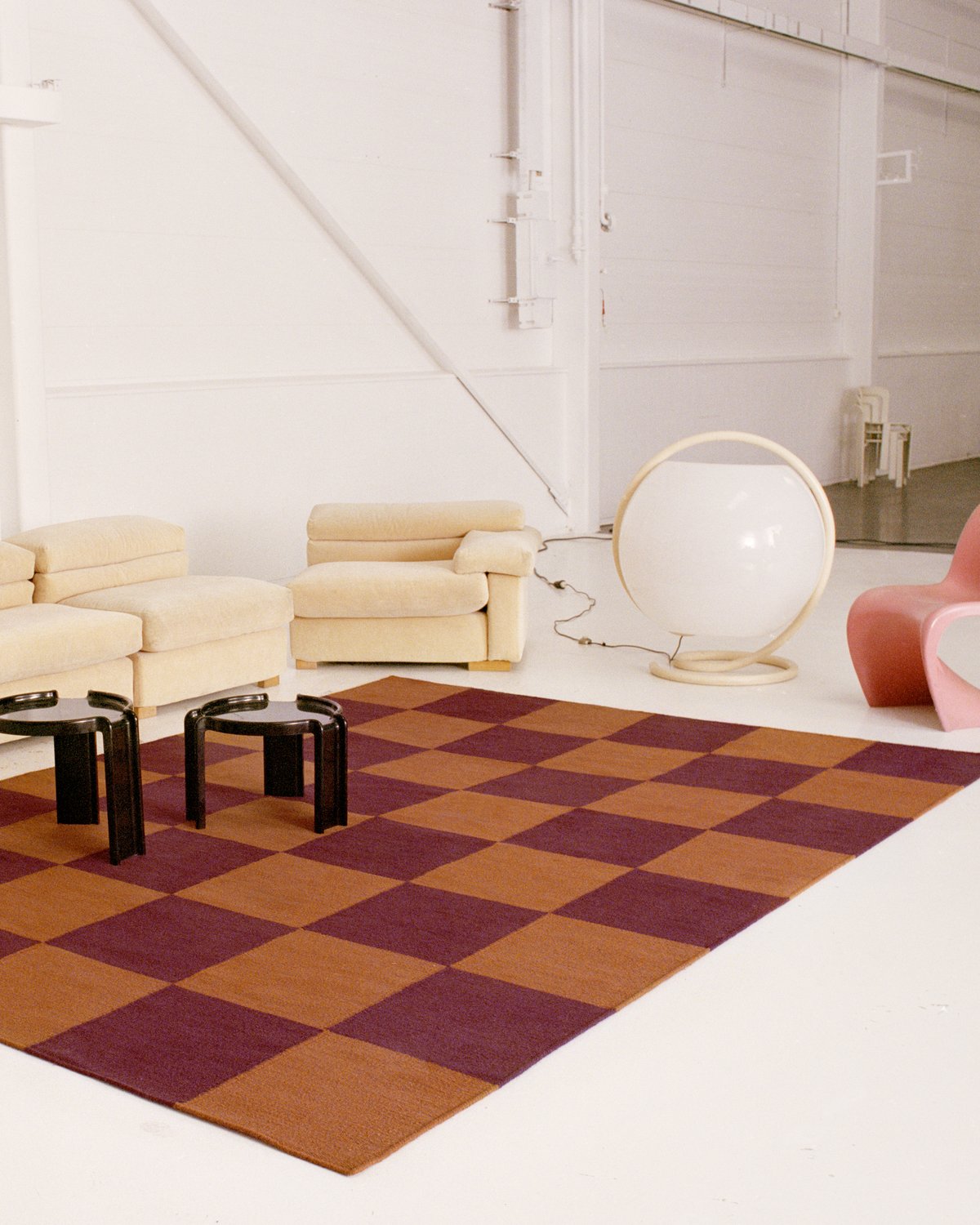 Industrial warehouse setting with modern furniture and Square Red/Orange rug. Shot in Amsterdam.