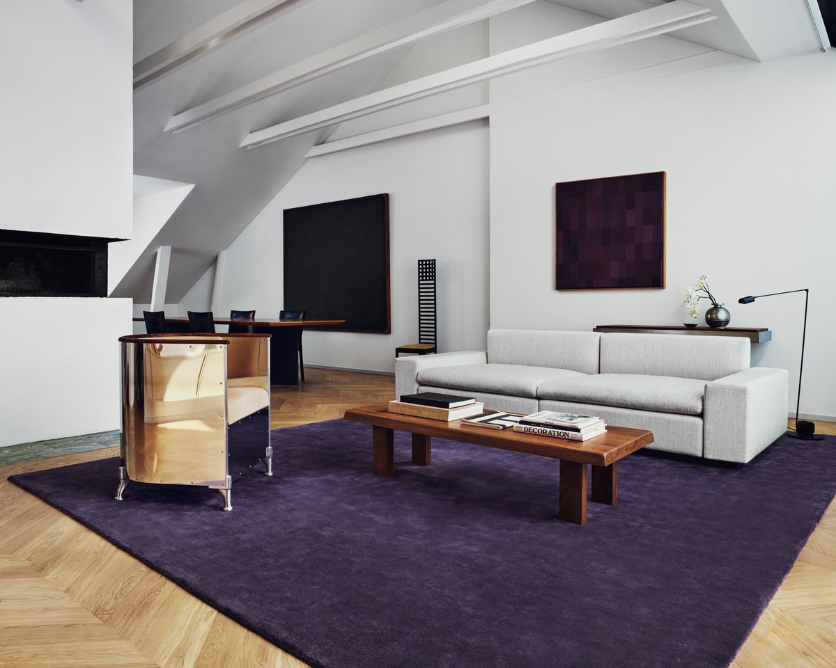 Plush wool rug Grand in Lilac pictured in a Stockholm apartment living room with chrome armchairs and gray sofa.