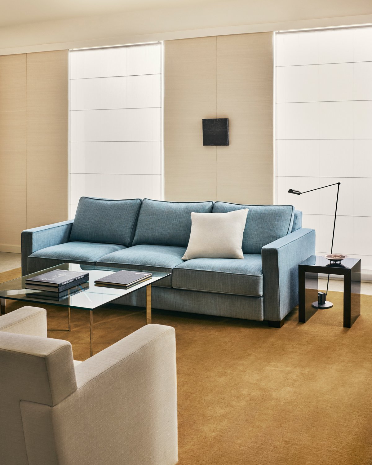 Grand in Leo, photographed in a bright living room beneath a pale blue sofa and a glass coffee table.