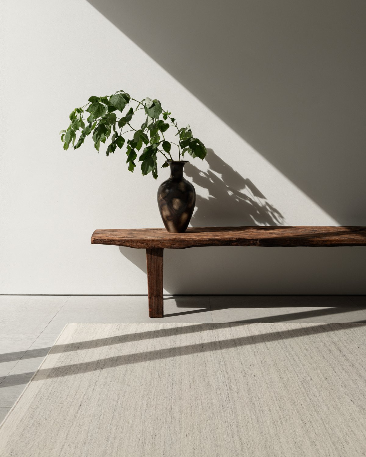 Zero en Cream Mix, présenté dans un cadre ensoleillé avec un banc en bois et un vase vintage en décoration.