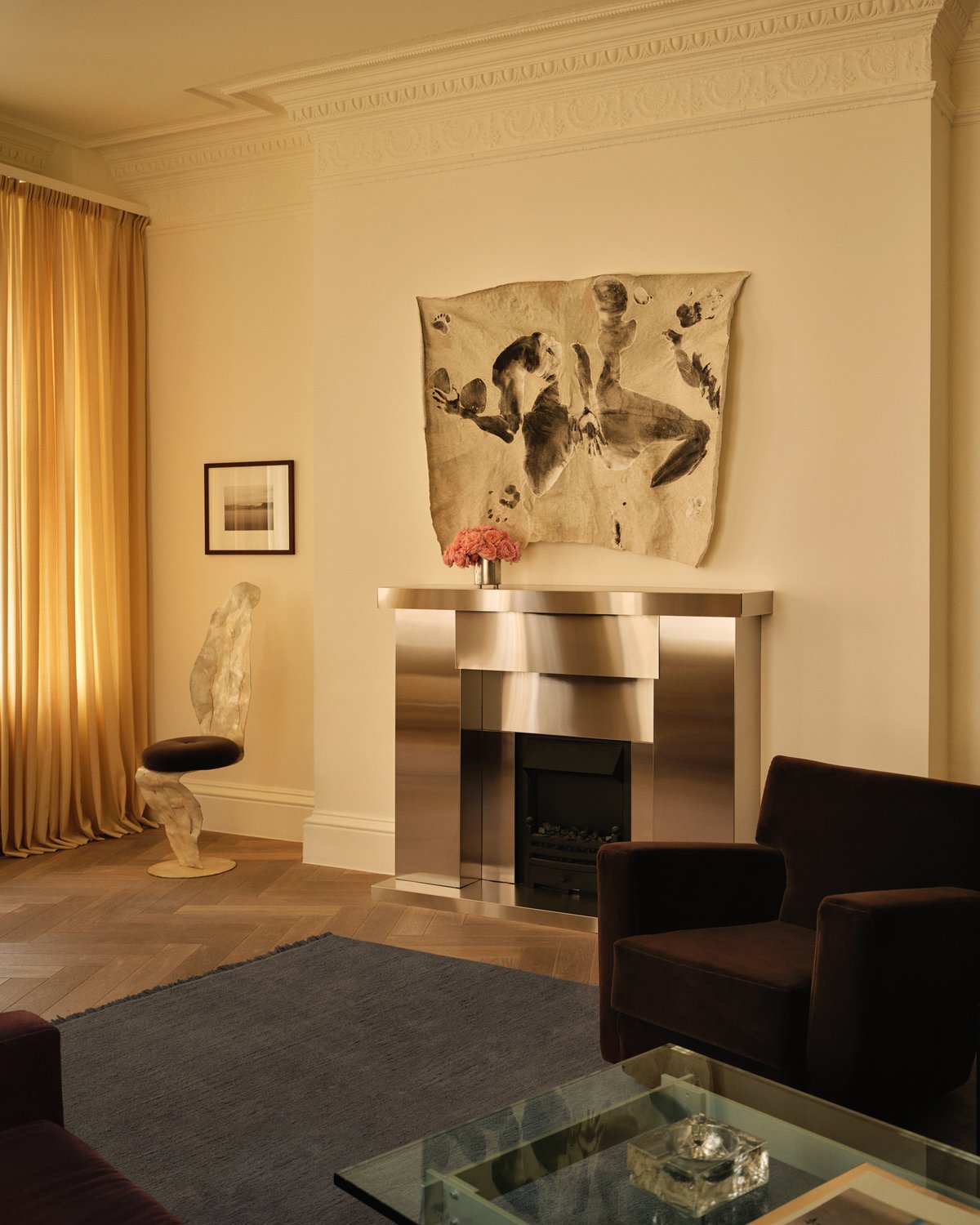 The Mohair rug in Slate Blue is shown in the Nordic Knots store on Mount Street in London, styled in a refined living room setting with golden curtains, a metallic fireplace, and sculptural furniture.