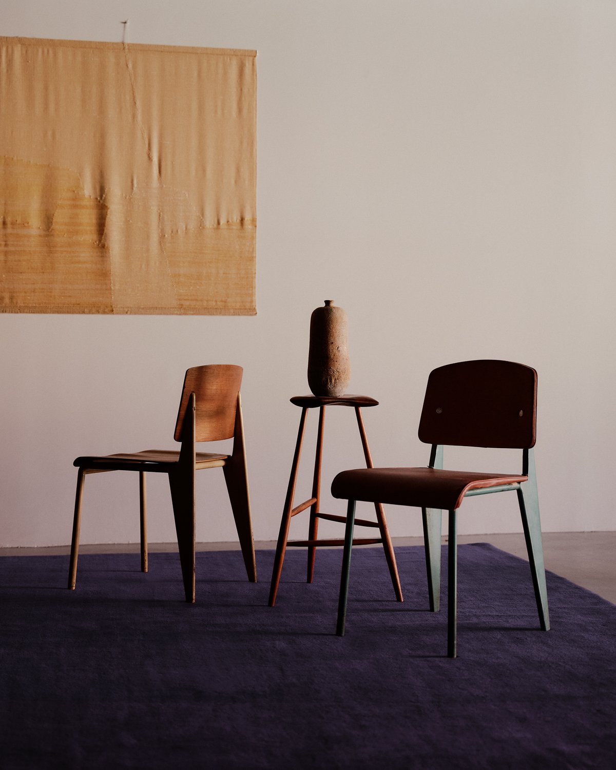 Tapis en laine moelleux Grand en coloris Lilac photographié avec des chaises modernes et une tapisserie murale jaune.