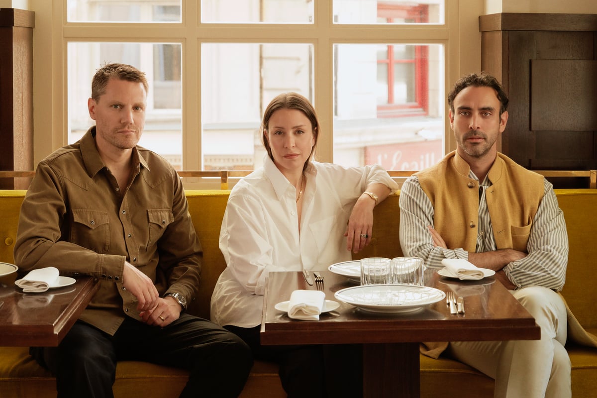 Nordic Knots founders Fabian Berglund and Liza Laserow photographed with Parisian designer Fabrizio Casiraghi by a table in brightly lit restaurant in Paris, France.
