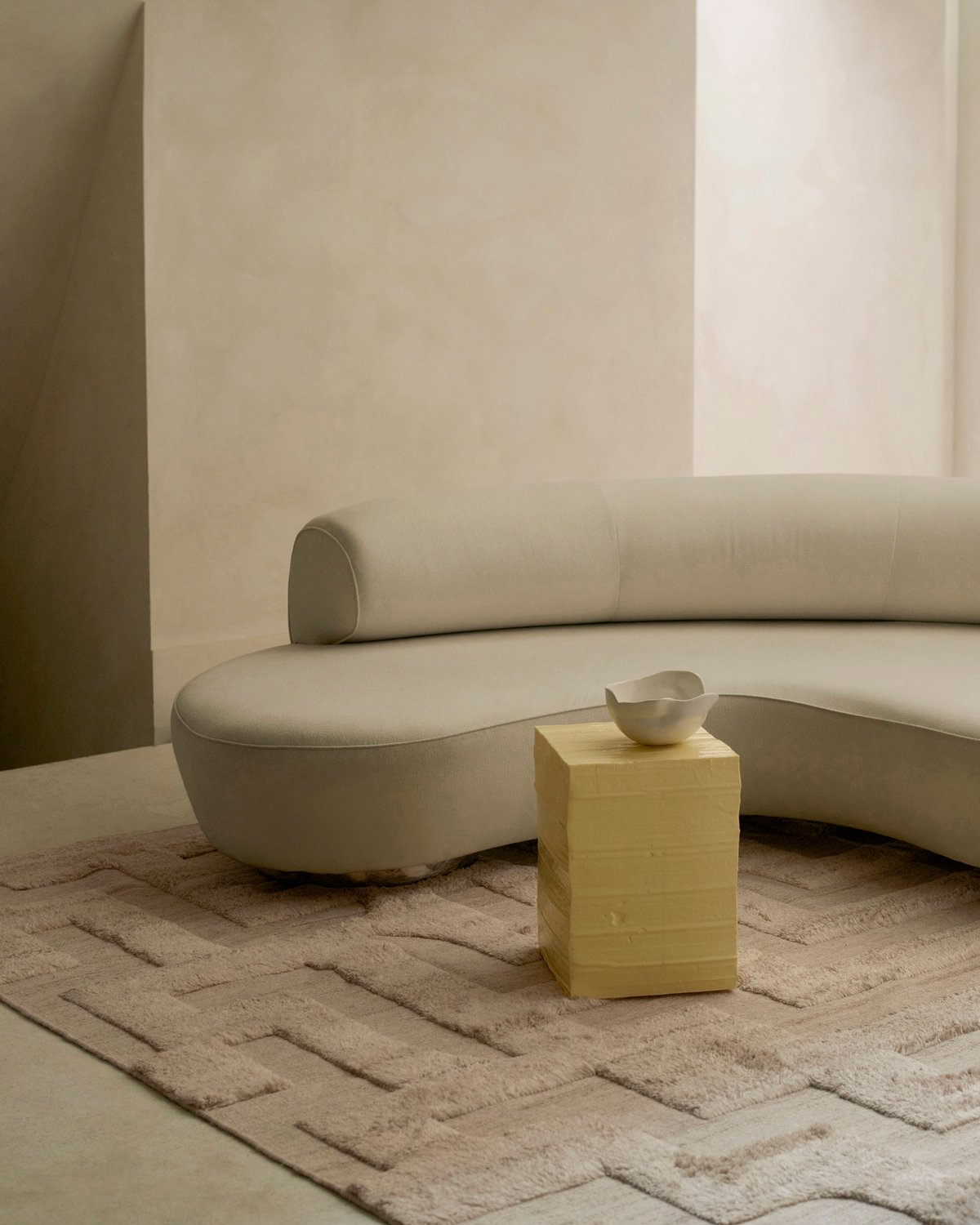 Zotteliger Wollteppich Boho Sand Mix abgebildet in einem modernen Loungezimmer mit künstlerischen Innendetails und einem weichen weißen Sofa in London.