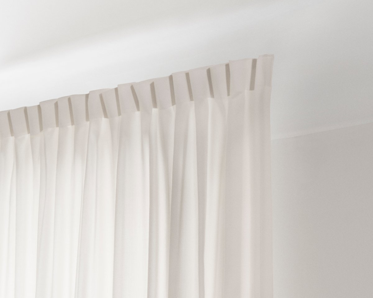 An image showing the installed The Grand wool curtains with the 1-finger hooks on a track.