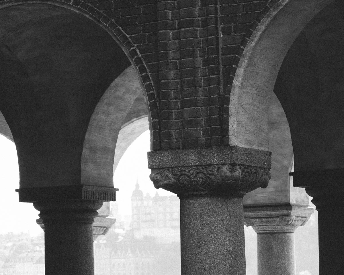 Bild av toppen av stenpelare som ansluter till ett tak.