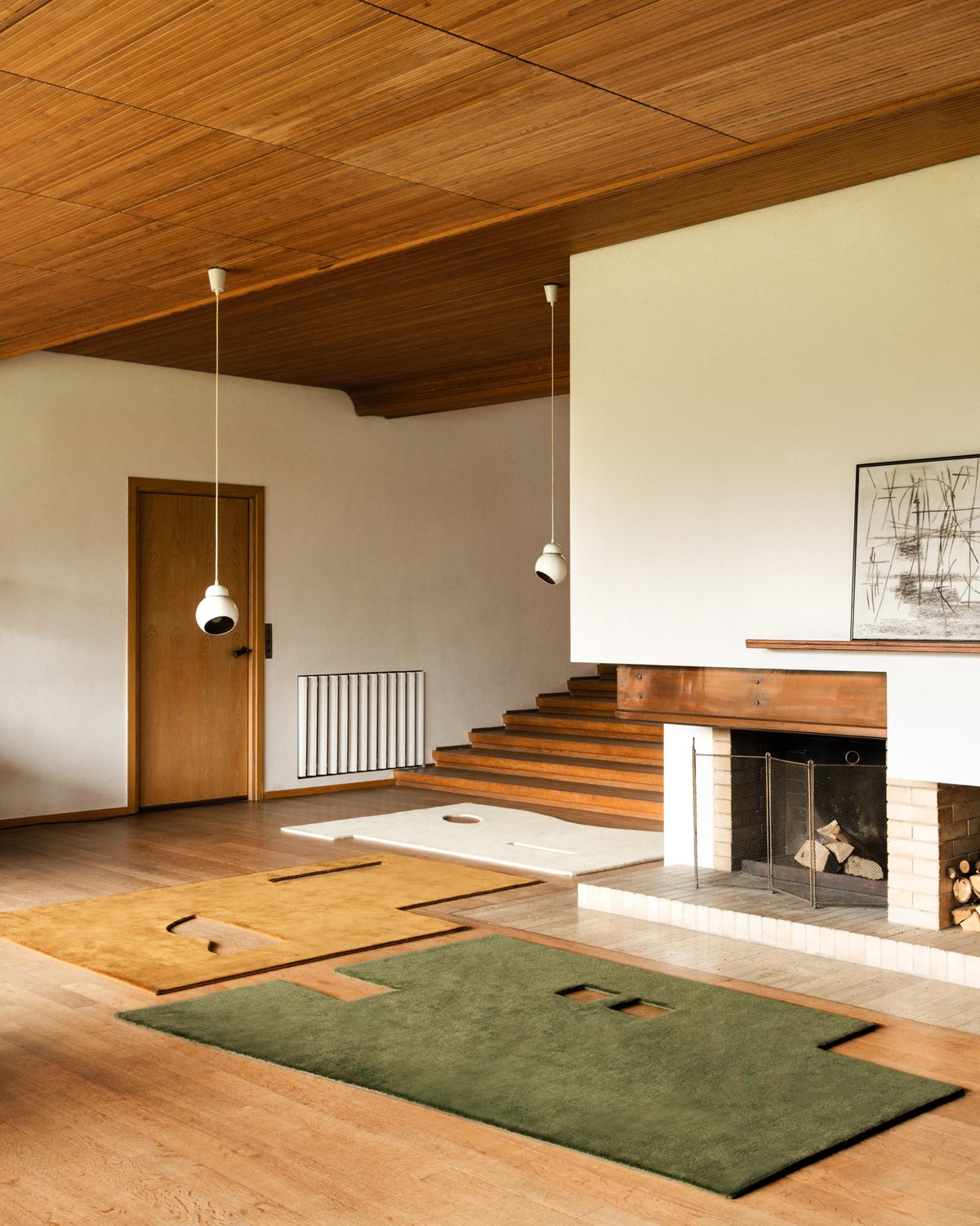 Geometrisch geformte Garance-Teppiche in den Farben Dusty White, Moss und Leo ausgestellt in einem Haus im Mid-Century-Stil.