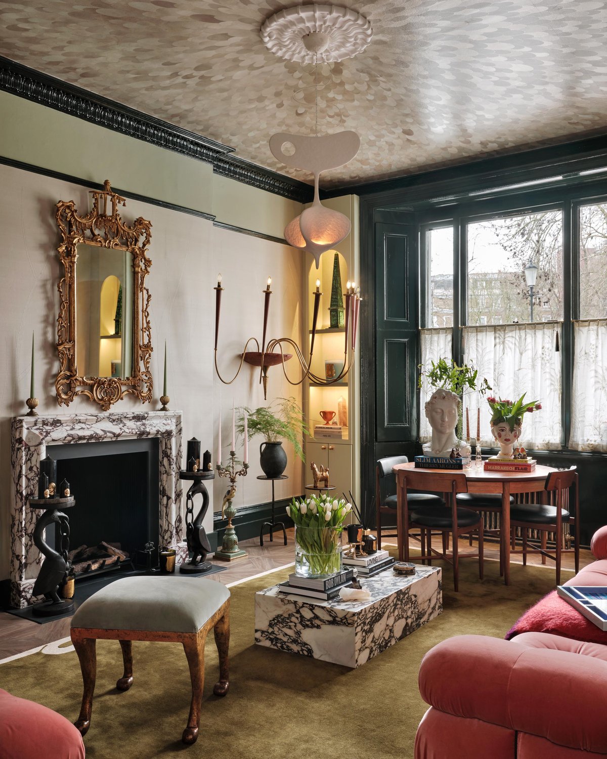 Eclectic living room with ornate gold mirror, marble fireplace, statement chandelier, and the Loops – Green rug adding a soft textured foundation to the space.
