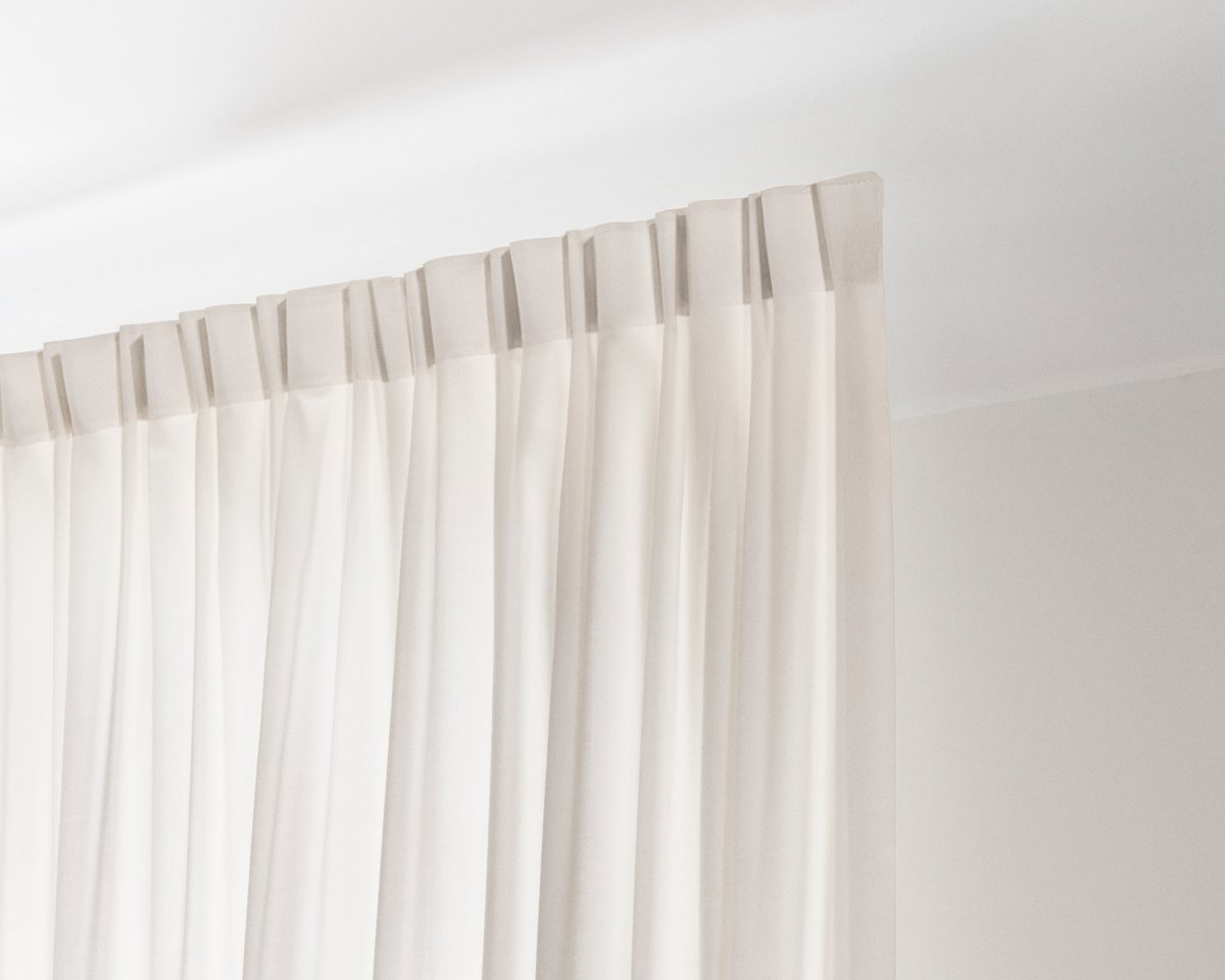 An image showing the installed The Grand wool curtains with the 2-finger hooks on a track.