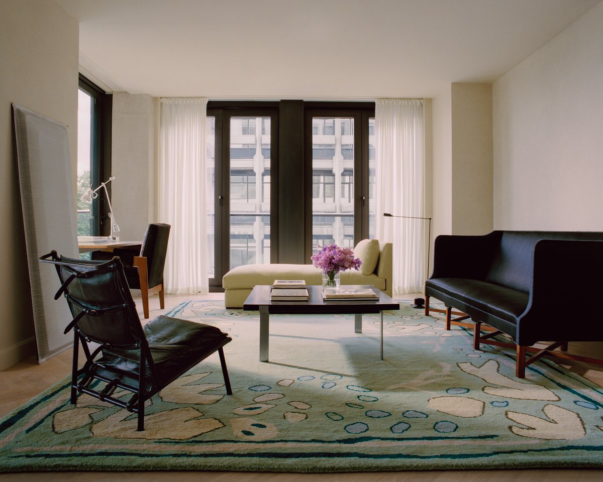 Giverny in Green photographed in a bright living room with tall windows. Styled with modern seating in dark accents.