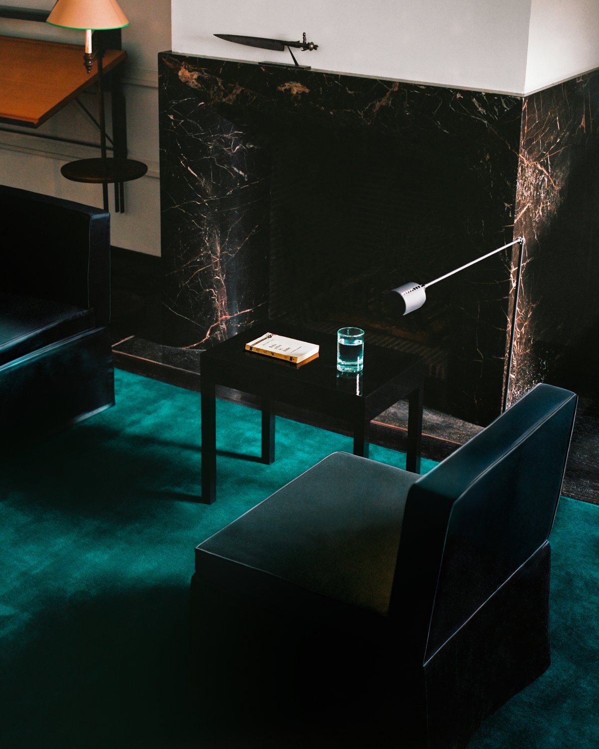 Grand in Emerald Green, photographed in a living room beneath black seating and a low table.