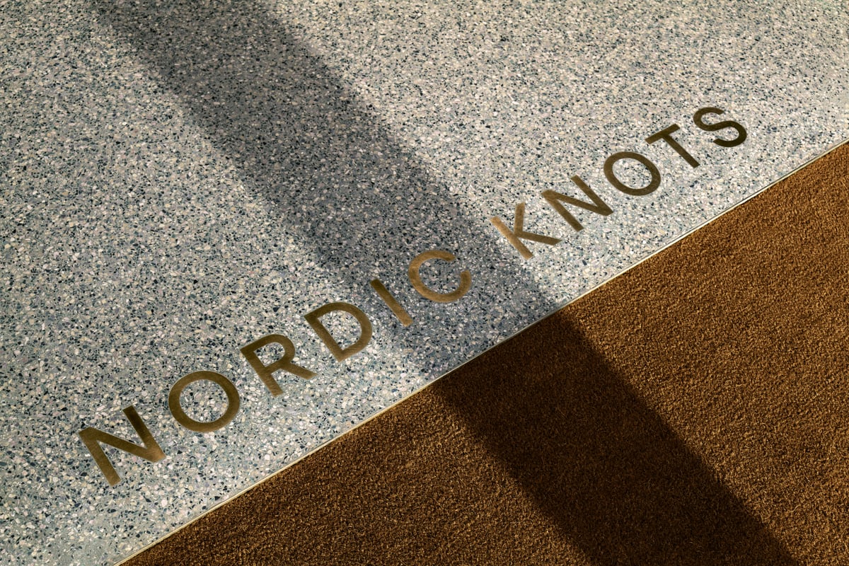 Gros plan sur le logo Nordic Knots en doré à l’entrée du showroom.