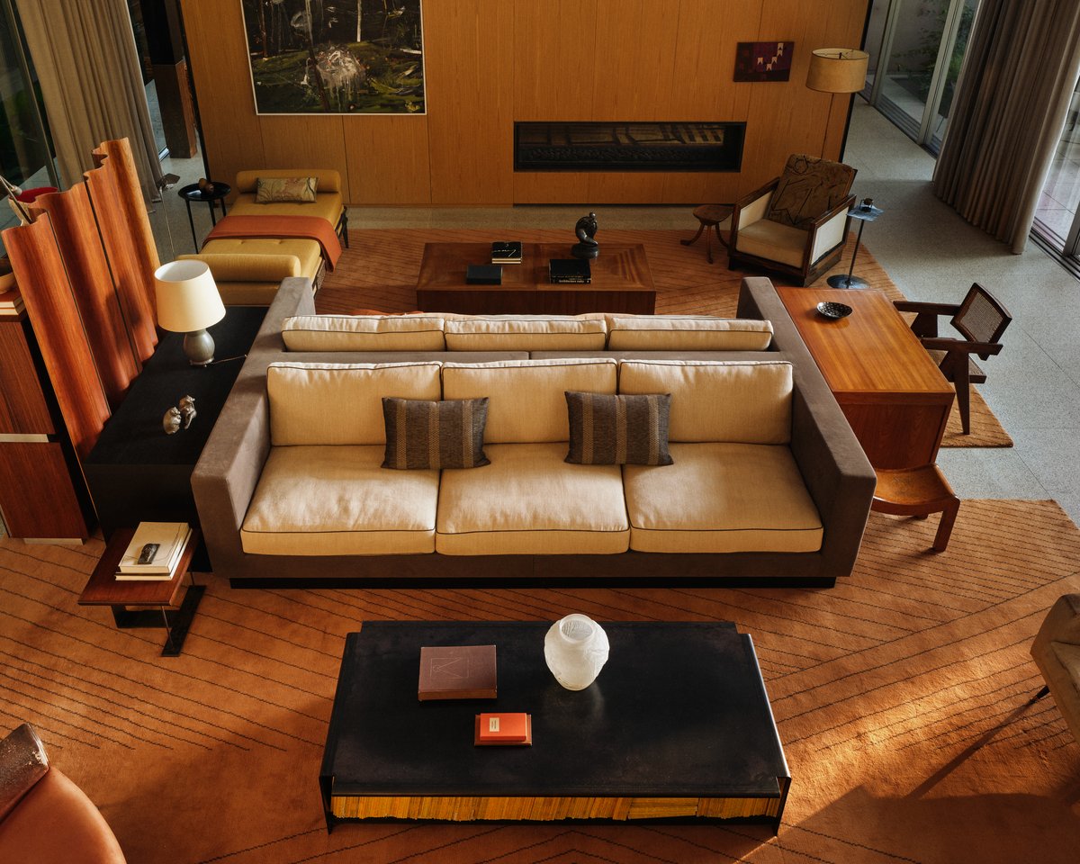 The Indore rug in Terracotta, styled in a São Paulo living room with mid-century furniture, warm wood floors, and layered seating.