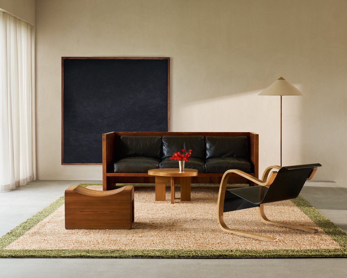 Shaggy wool rug Ryya in Beige pictured in a minimalistic living room with leather detailed wooden furniture.