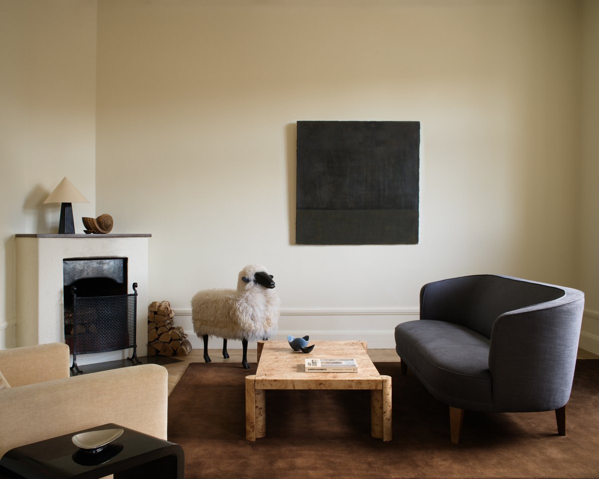 Grand Chestnut rug in a living room setting with a grey couch, fireplace, and sheep statue.