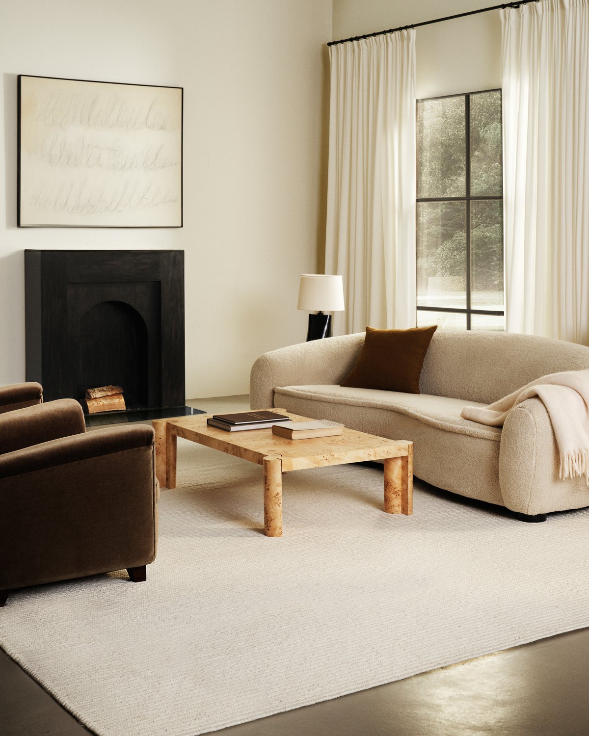 Flatweave wool rug Braid in Cream pictured in a living room with a black fireplace and white sofa.