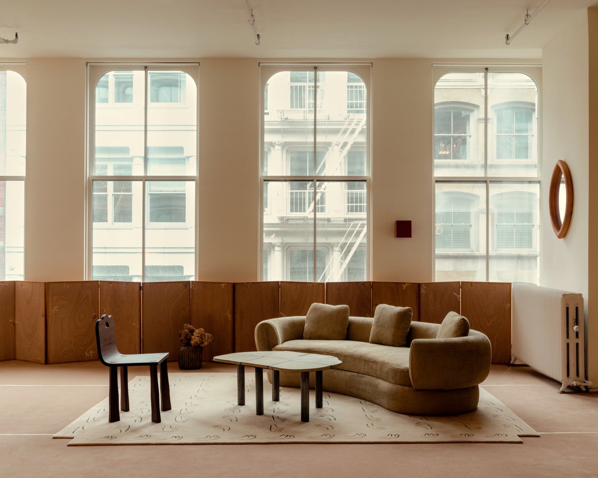 All Hands Beige rug pictured in a NYC apartment with large windows.