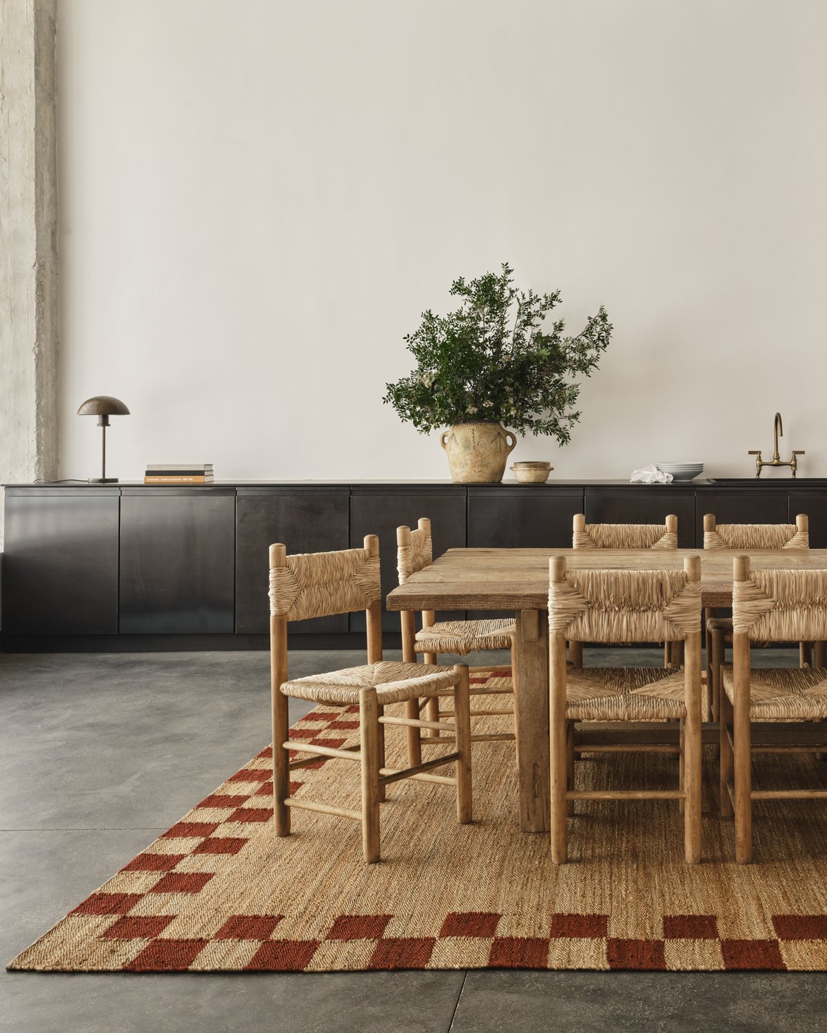 Tapis en jute Border Red photographié dans une salle à manger spacieuse et lumineuse avec une grande table en bois et des chaises assorties à Athènes, Grèce.