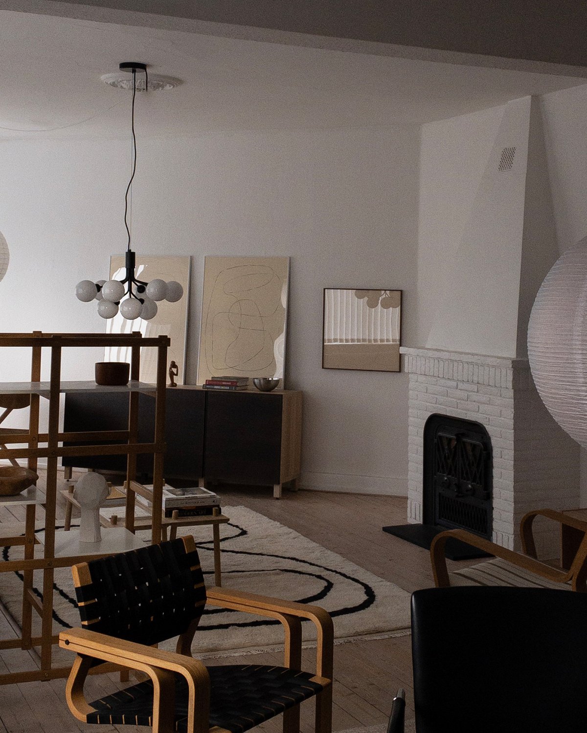 Tapis en laine shaggy Simple Object 18 photographié dans un salon faiblement éclairé avec des meubles en bois et une grande cheminée.