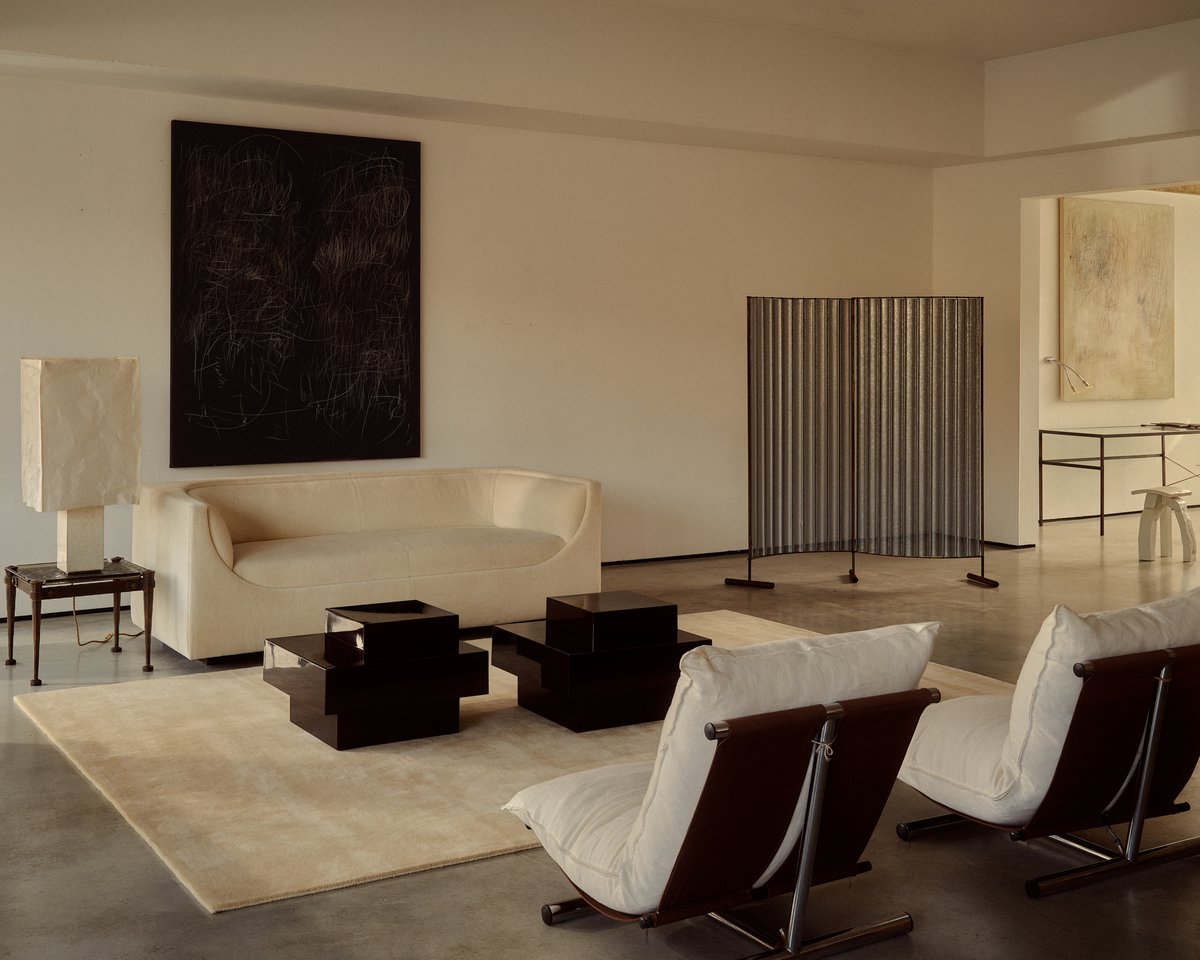 Mattan Grand i färgen Butter, i ett ljust vardagsrum med moderna, skulpturala möbler. Skapar en noggrant kurerad miljö.