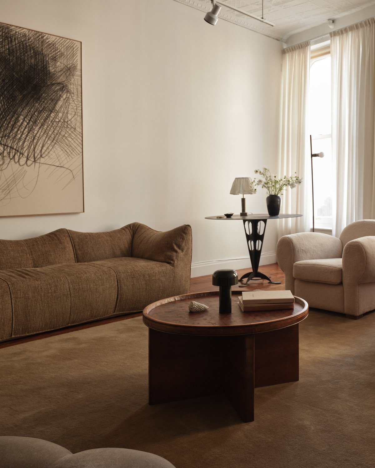 Plush wool rug Grand Chestnut pictured in a stunning New York living room with neutral colored furniture and a large painting.