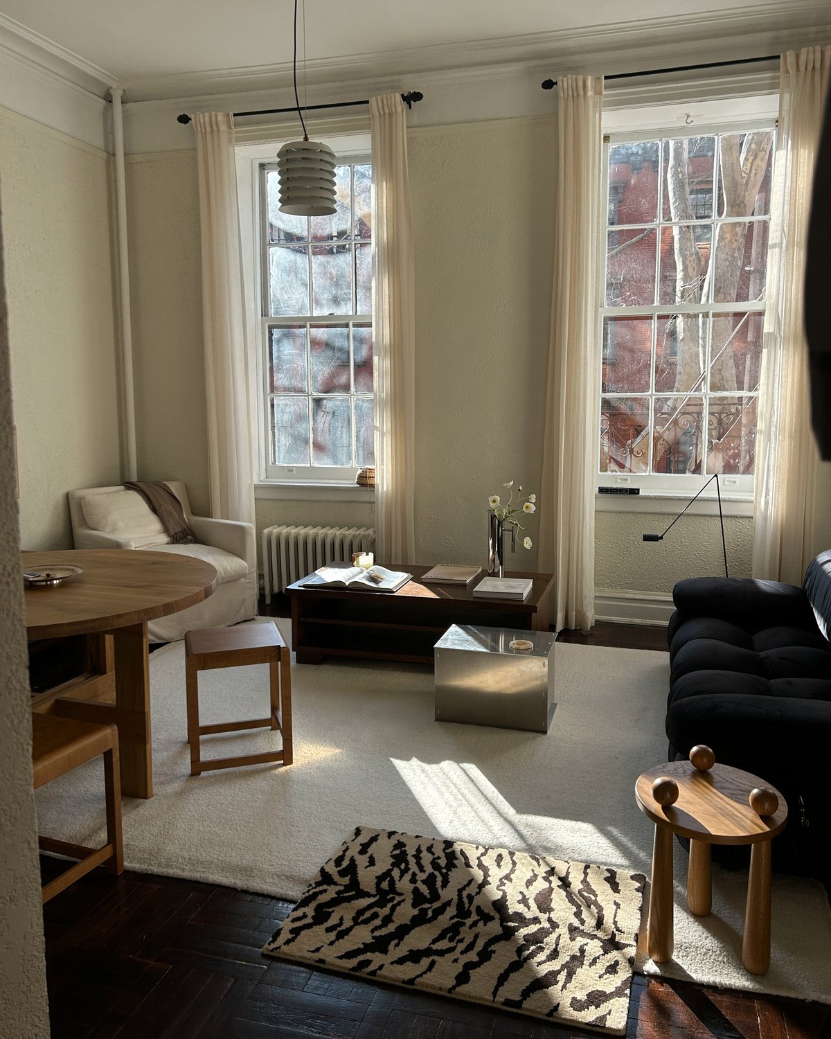 Photograph of Jessie Andrew's living room with neutral colored furniture and a large sample of the plush wool rug Tigris x Nordic Knots.