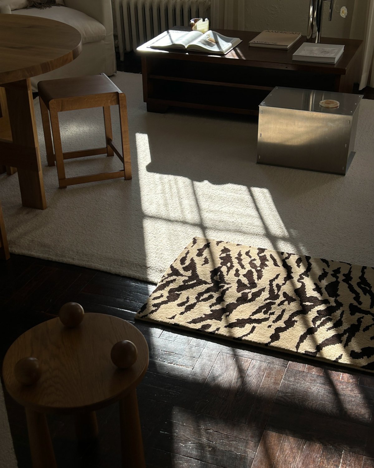 Photograph of Jessie Andrew's living room with neutral colored furniture and a large sample of the plush wool rug Tigris x Nordic Knots.