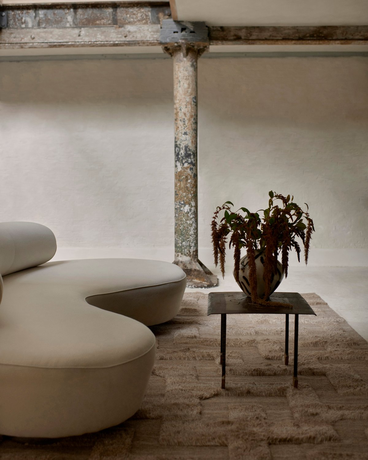 Shaggy-Wollteppich Boho Brown Mix, abgebildet in einem Lounge-Raum im modernen Brutalismus-Stil mit architektonischen Metalldetails und einem weichen weißen Sofa in London.