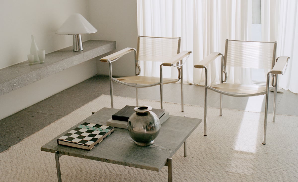 Zero Basket – Sand Mix brings quiet texture and warmth to this minimal setting. Its handwoven surface softens the clean lines of chrome-framed chairs and a stone table, while sheer curtains filter light across the calm, tonal palette.