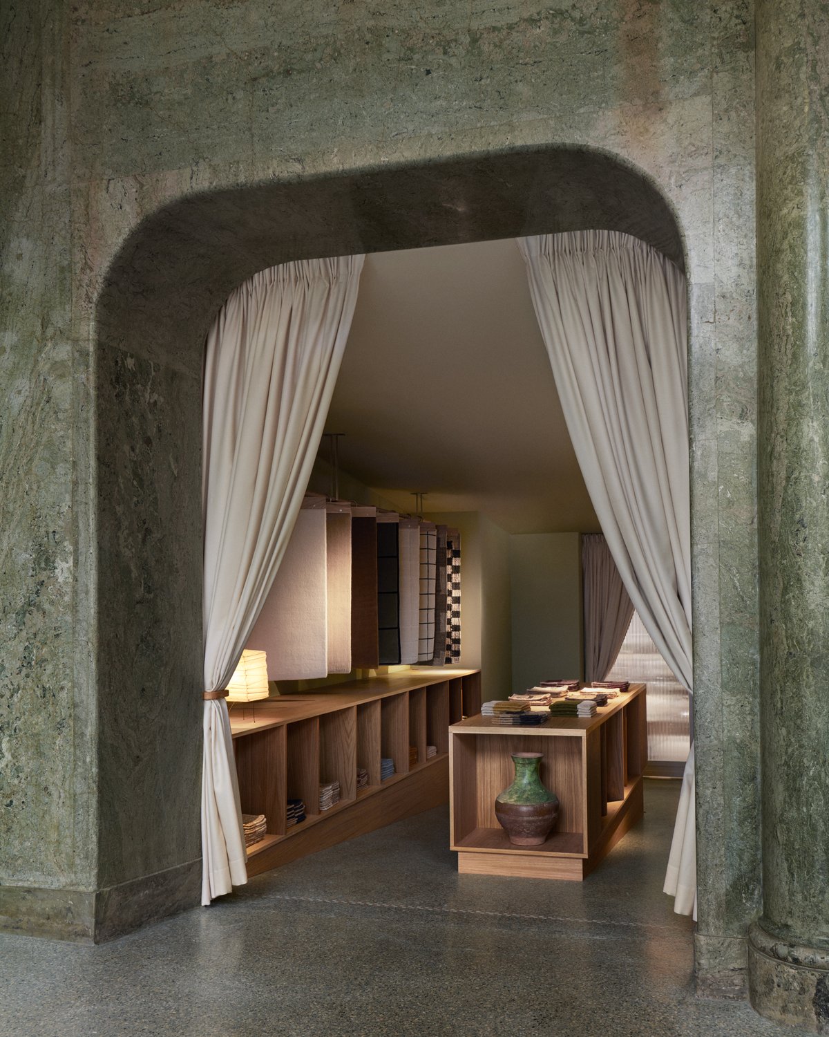 Entrée en marbre vert menant aux échantillons de tapis dans le flagship Nordic Knots.