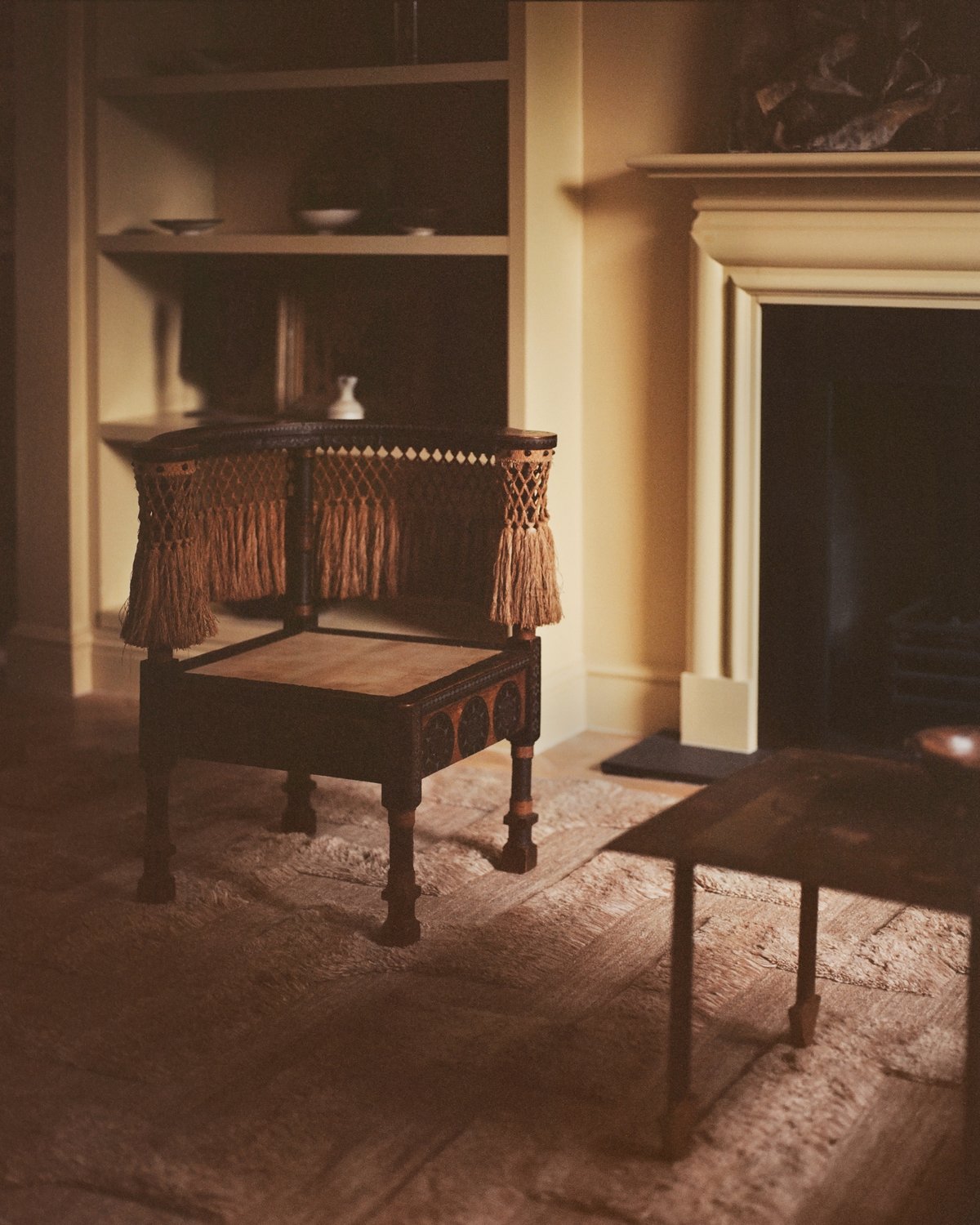 German Shaggy-Wollteppich Boho, auf Analogfilm aufgenommen, in einem gemütlichen Wohnzimmer mit Holzelementen im Interieur vor einem Kamin in London.