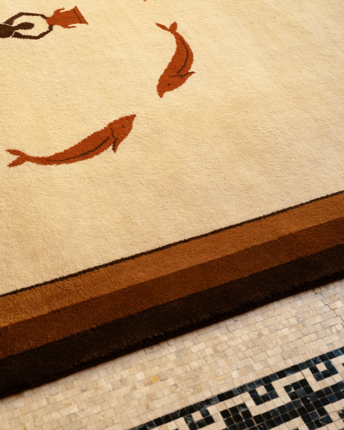 Close up of plush wool rug designed by Parisian designer Fabrizio Casiraghi on a tile floor with an intricate blue pattern in Paris, France.