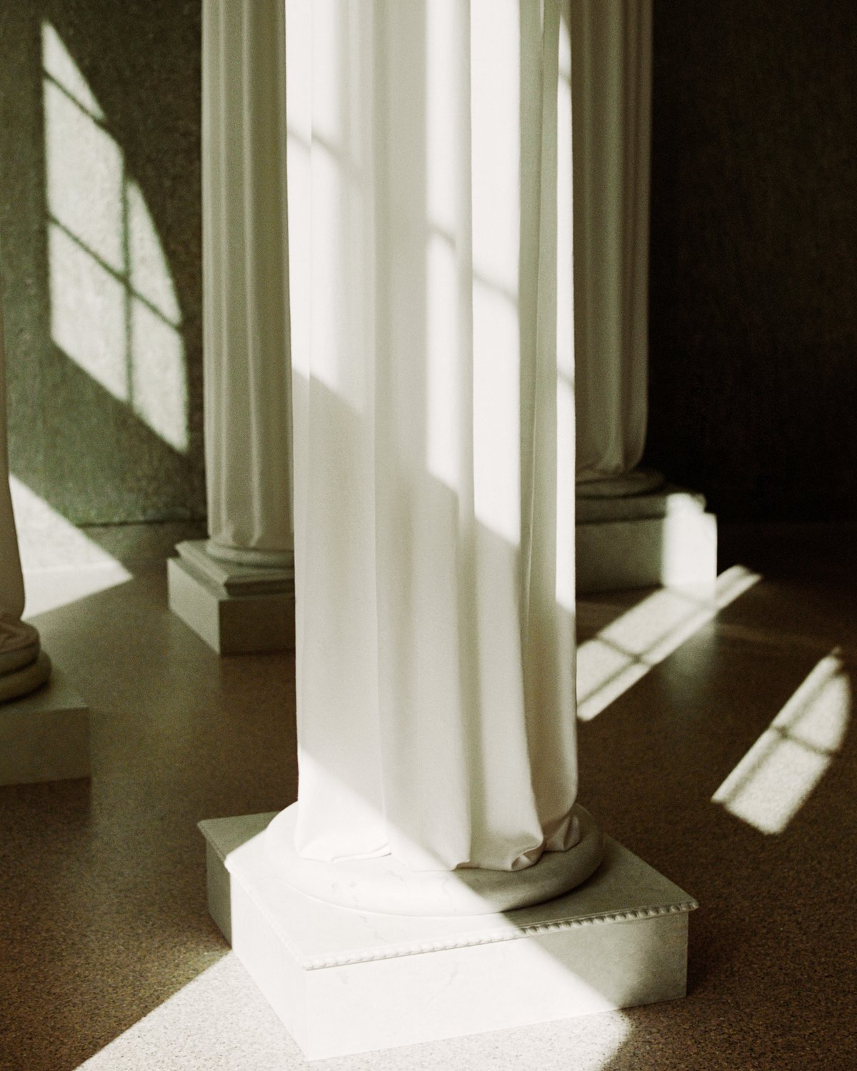 The Grand curtains photographed on ancient greek style pillars in the Stockholm Flagship store with a marble wall background.