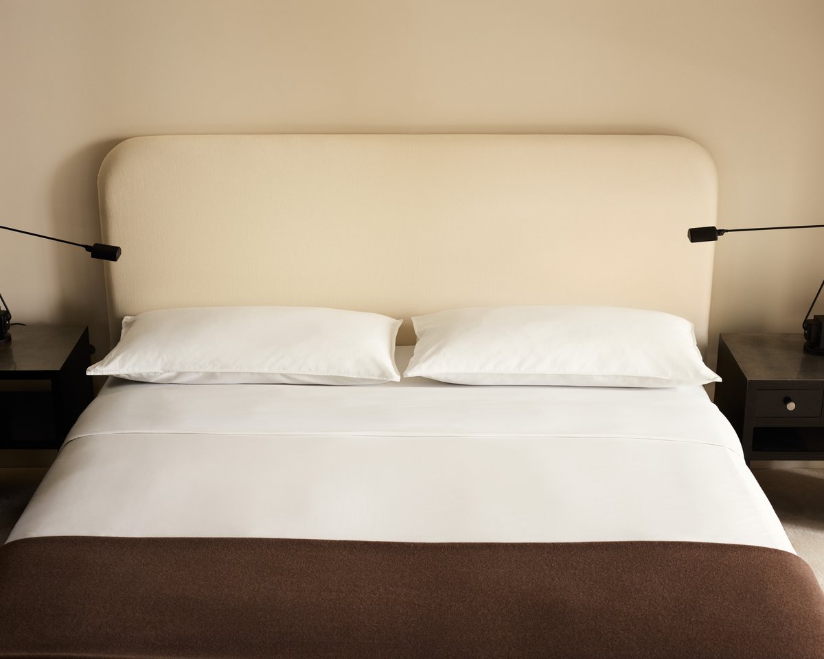 Bed styled with the Signature Headboard in Warm White, dressed in Crisp White bedding, finished with the Heritage Throw in Taupe.