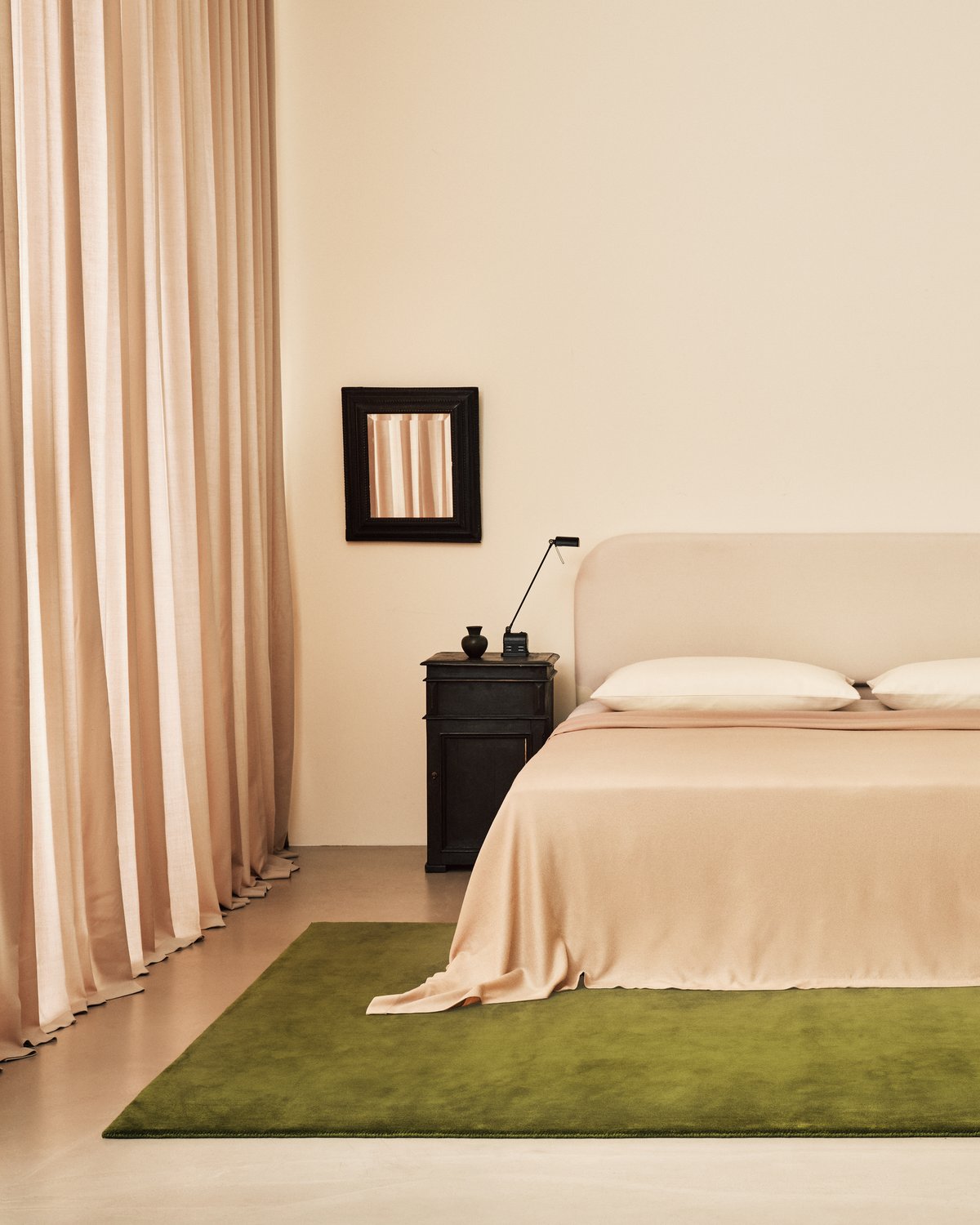 Die The Grand Vorhänge in Old Rose abgebildet in einem minimalistischen Schlafzimmer mit dem flauschigen Wollteppich Grand in Milano Green.