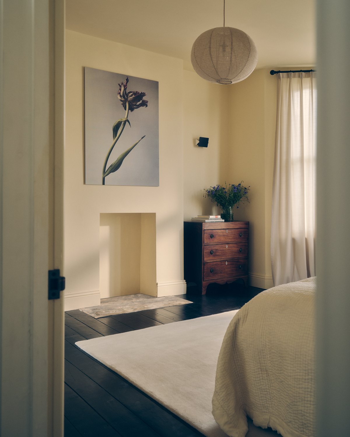 Tapis en laine moelleux Grand en Dusty White photographié dans une chambre lumineuse avec des meubles et des murs couleur crème.